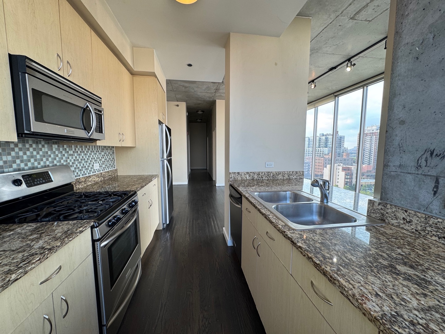 1720 South Michigan Avenue, Unit 1401 Chicago, IL 60616 - Photo 5 of 13 a kitchen with stainless steel appliances granite countertop a sink stove and refrigerator