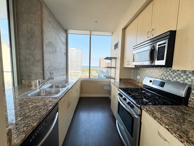 a kitchen with sink stove and cabinets