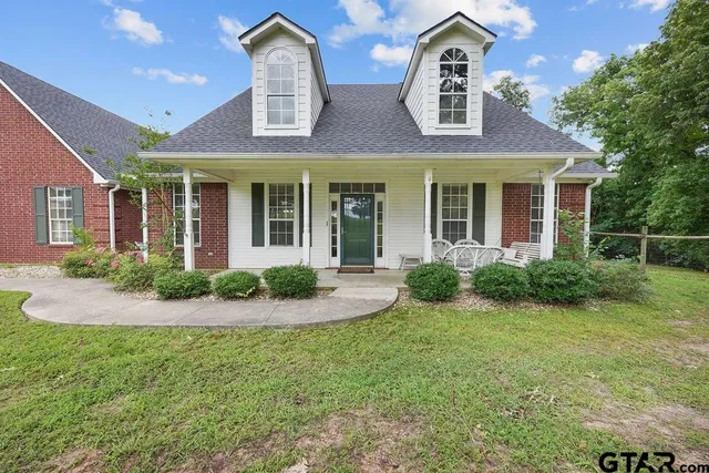 front view of a brick house with a yard