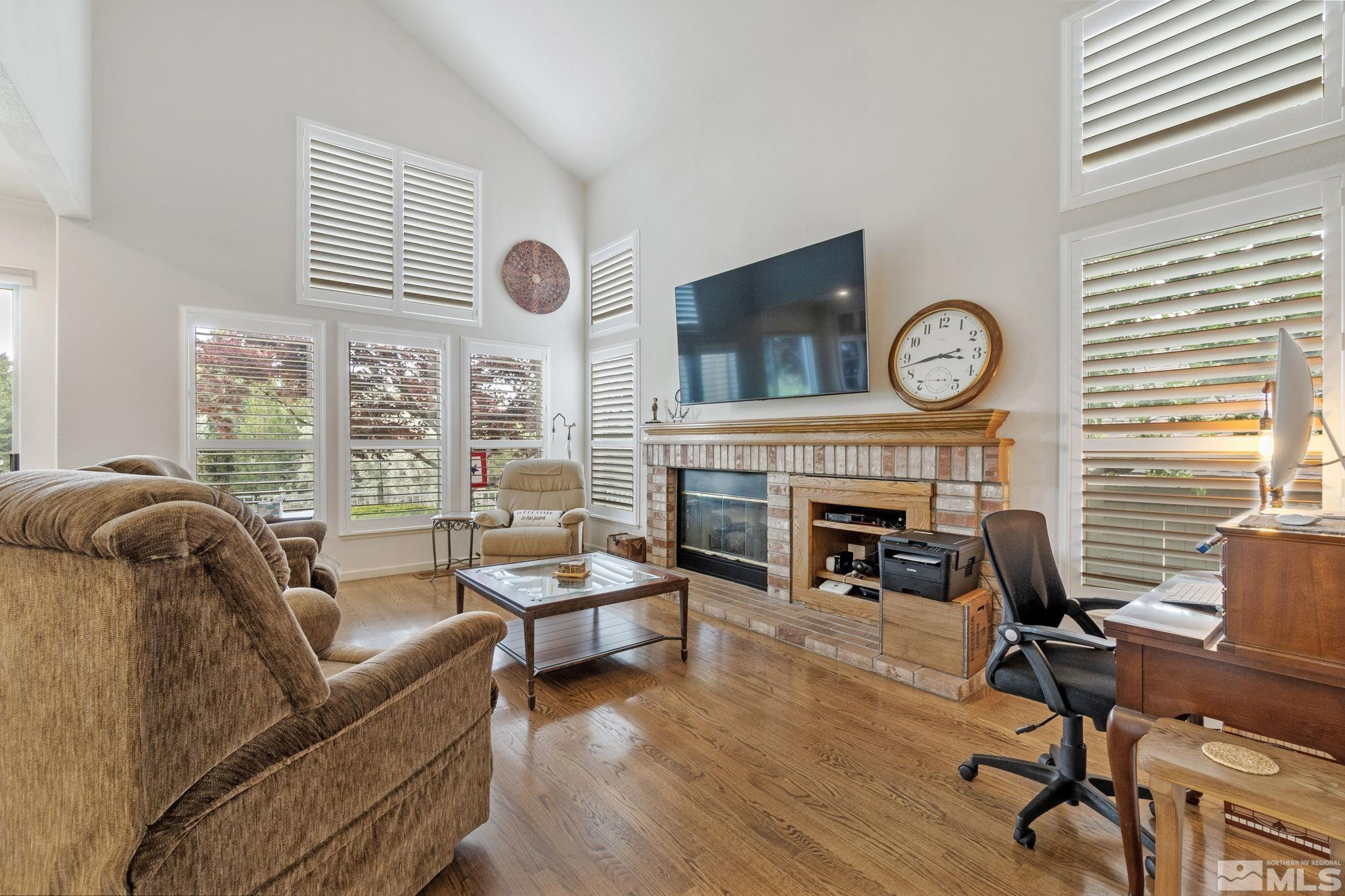 6142 Carriage House Way Reno, NV 89519 - Photo 16 of 40 a living room with furniture a fireplace and a large window