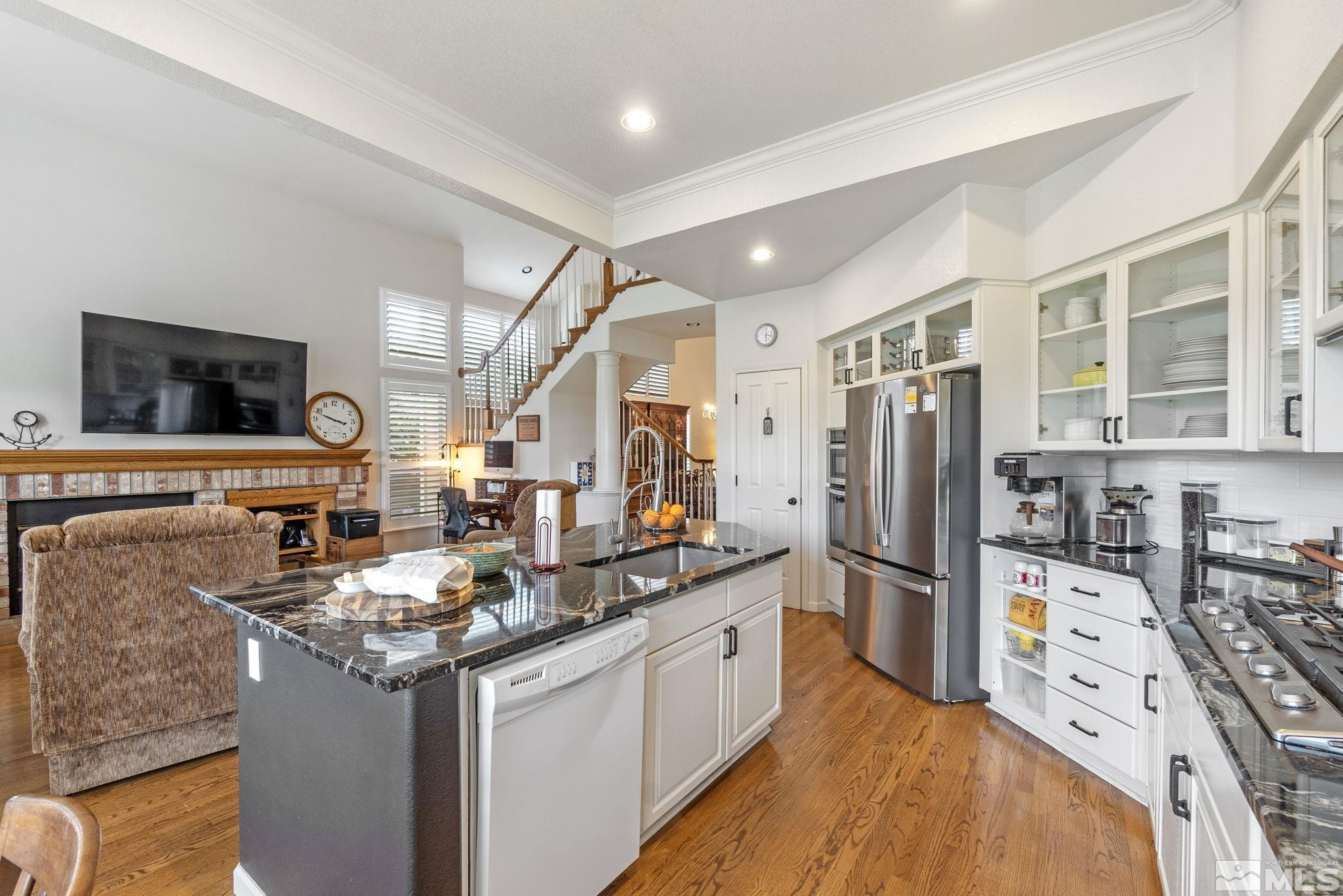 6142 Carriage House Way Reno, NV 89519 - Photo 22 of 40 a kitchen with stainless steel appliances kitchen island granite countertop a refrigerator and a stove top oven