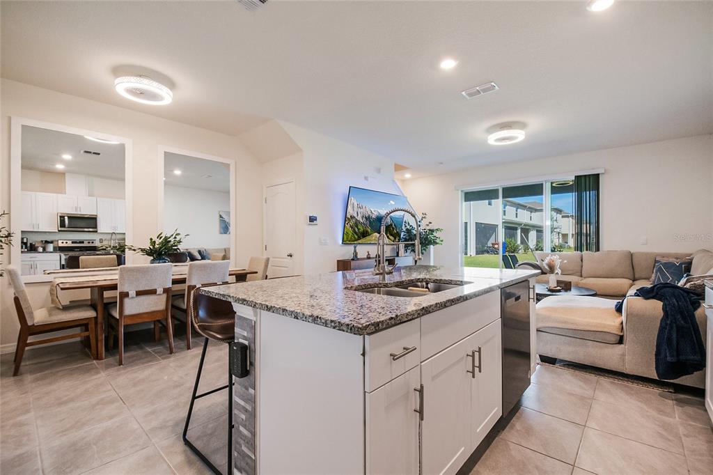 1359 Isleta Loop Kissimmee, FL 34741 - Photo 12 of 57 a kitchen with center island table and chairs in it