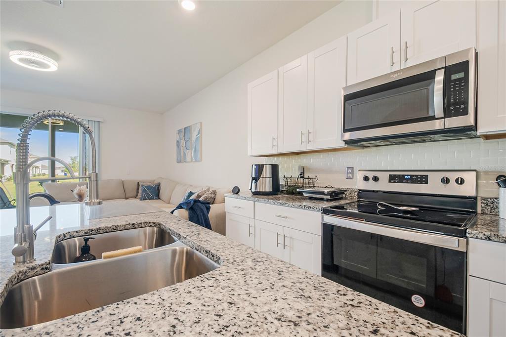 1359 Isleta Loop Kissimmee, FL 34741 - Photo 16 of 57 a kitchen with a stove and a microwave