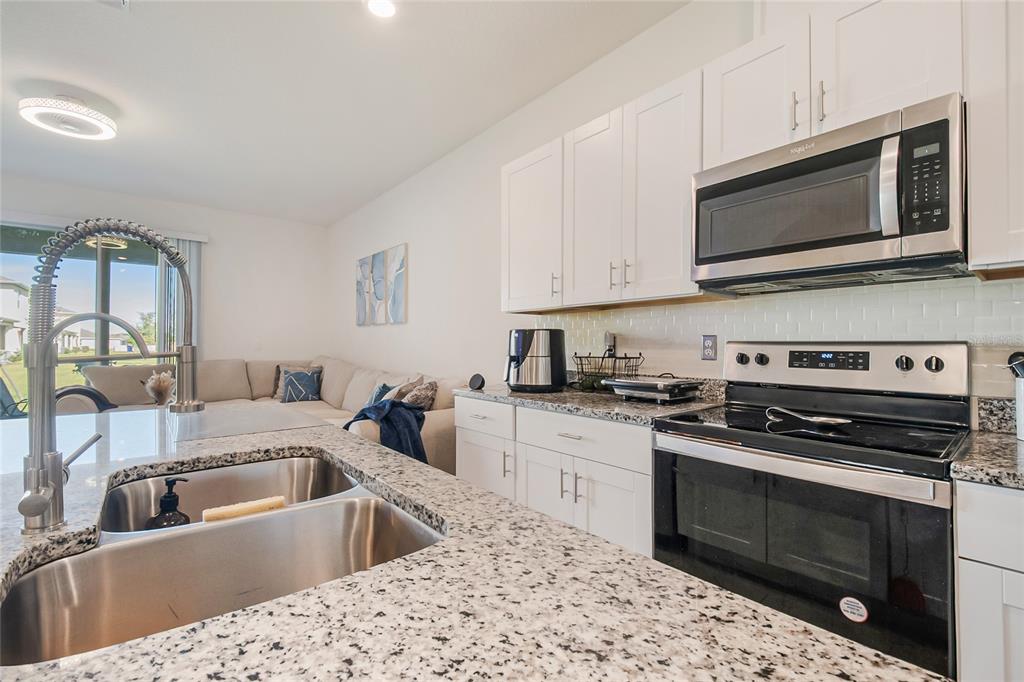 1359 Isleta Loop Kissimmee, FL 34741 - Photo 17 of 57 a kitchen with a stove and a sink