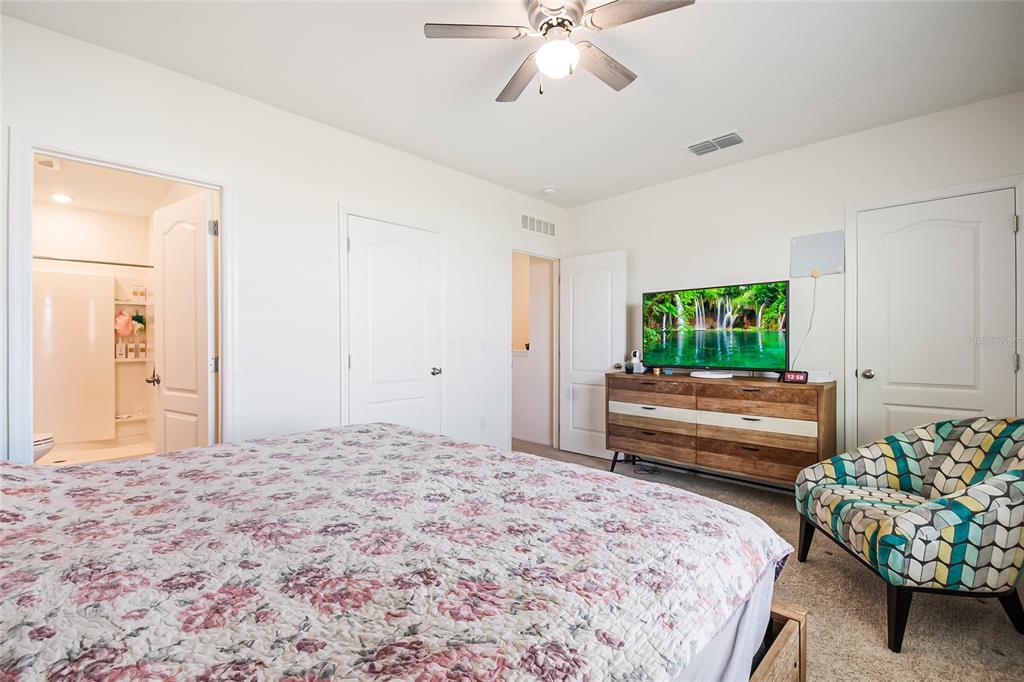 1359 Isleta Loop Kissimmee, FL 34741 - Photo 27 of 57 a bedroom with a bed and a chandelier