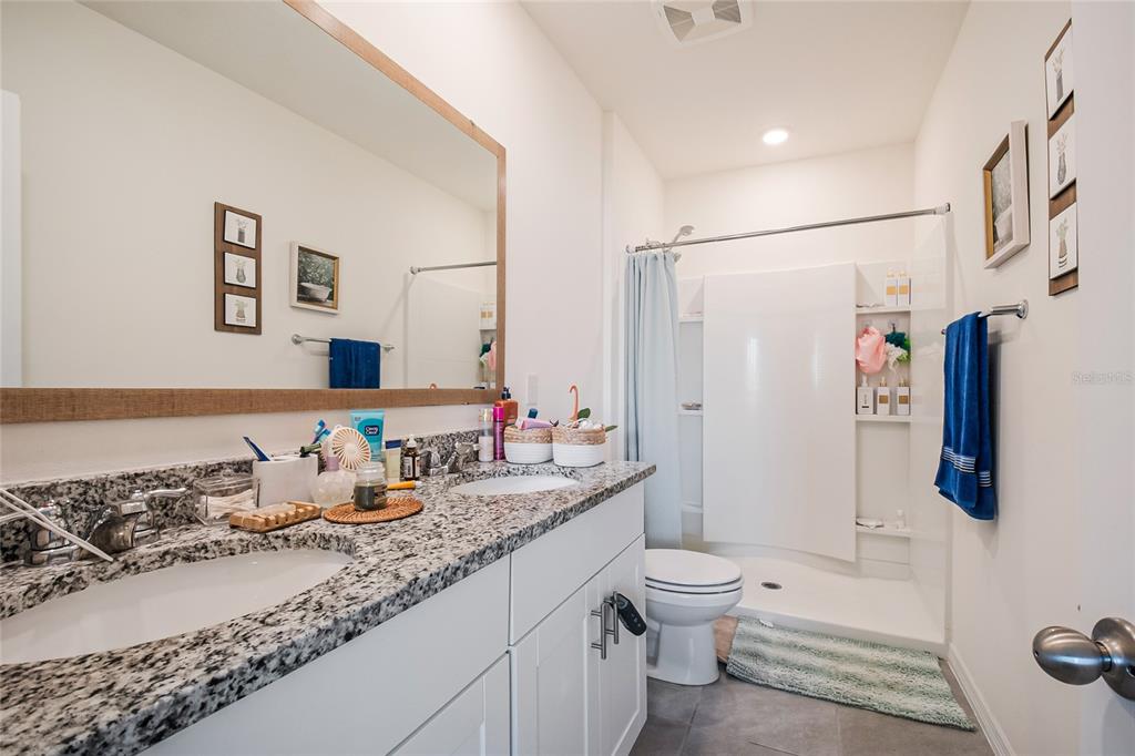 1359 Isleta Loop Kissimmee, FL 34741 - Photo 28 of 57 a bathroom with a granite countertop sink toilet and shower