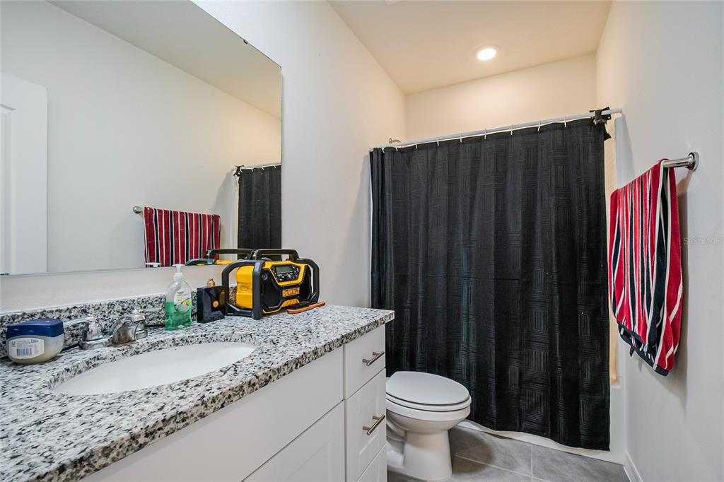 1359 Isleta Loop Kissimmee, FL 34741 - Photo 30 of 57 a bathroom with a granite countertop sink and a toilet