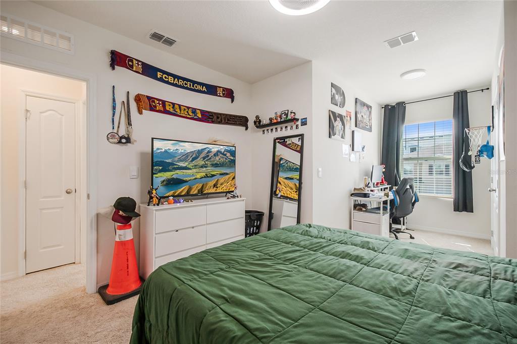 1359 Isleta Loop Kissimmee, FL 34741 - Photo 32 of 57 a bedroom with a bed and a flat tv screen