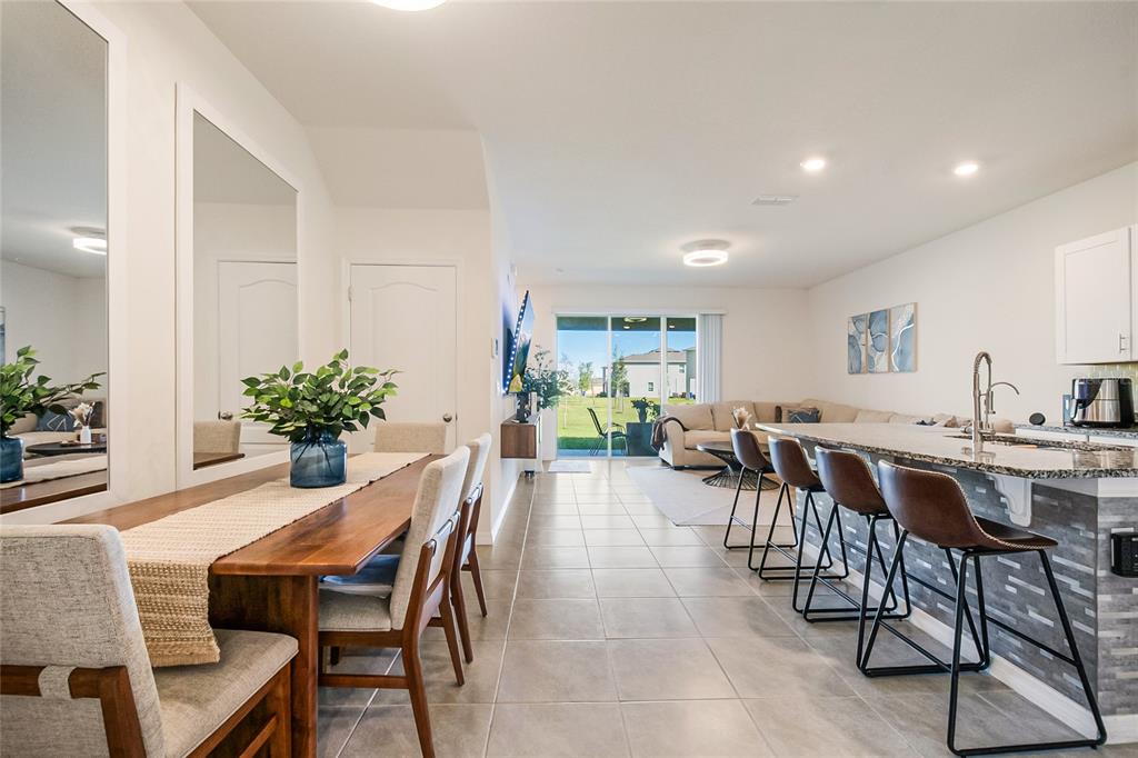 1359 Isleta Loop Kissimmee, FL 34741 - Photo 9 of 57 a dining room with furniture potted plants and wooden floor
