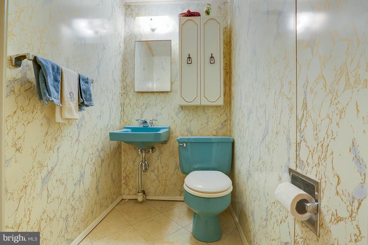 9007 Fieldchat Road Baltimore, MD 21236 - Photo 22 of 30 a bathroom with a toilet sink and mirror