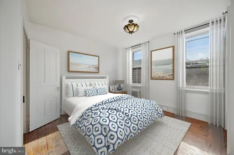 a bedroom with a bed and painting on the wall