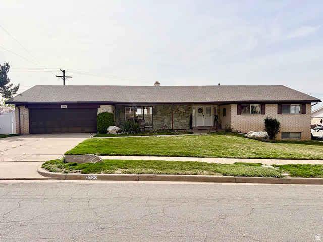2136 South 900 East Bountiful, UT 84010 - Photo 1 of 1 Single story home featuring a porch, a front lawn, concrete driveway, an attached garage, and brick siding
