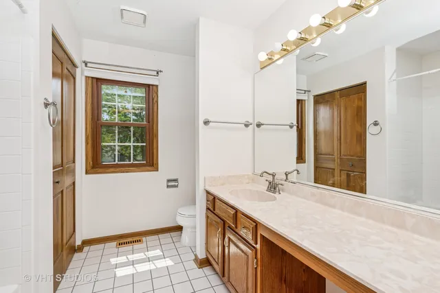 a bathroom with a granite countertop sink a mirror and a shower