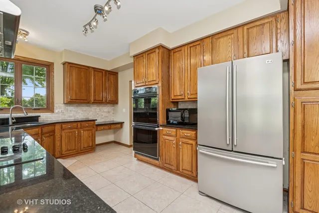 a kitchen with a refrigerator a stove top oven and cabinets