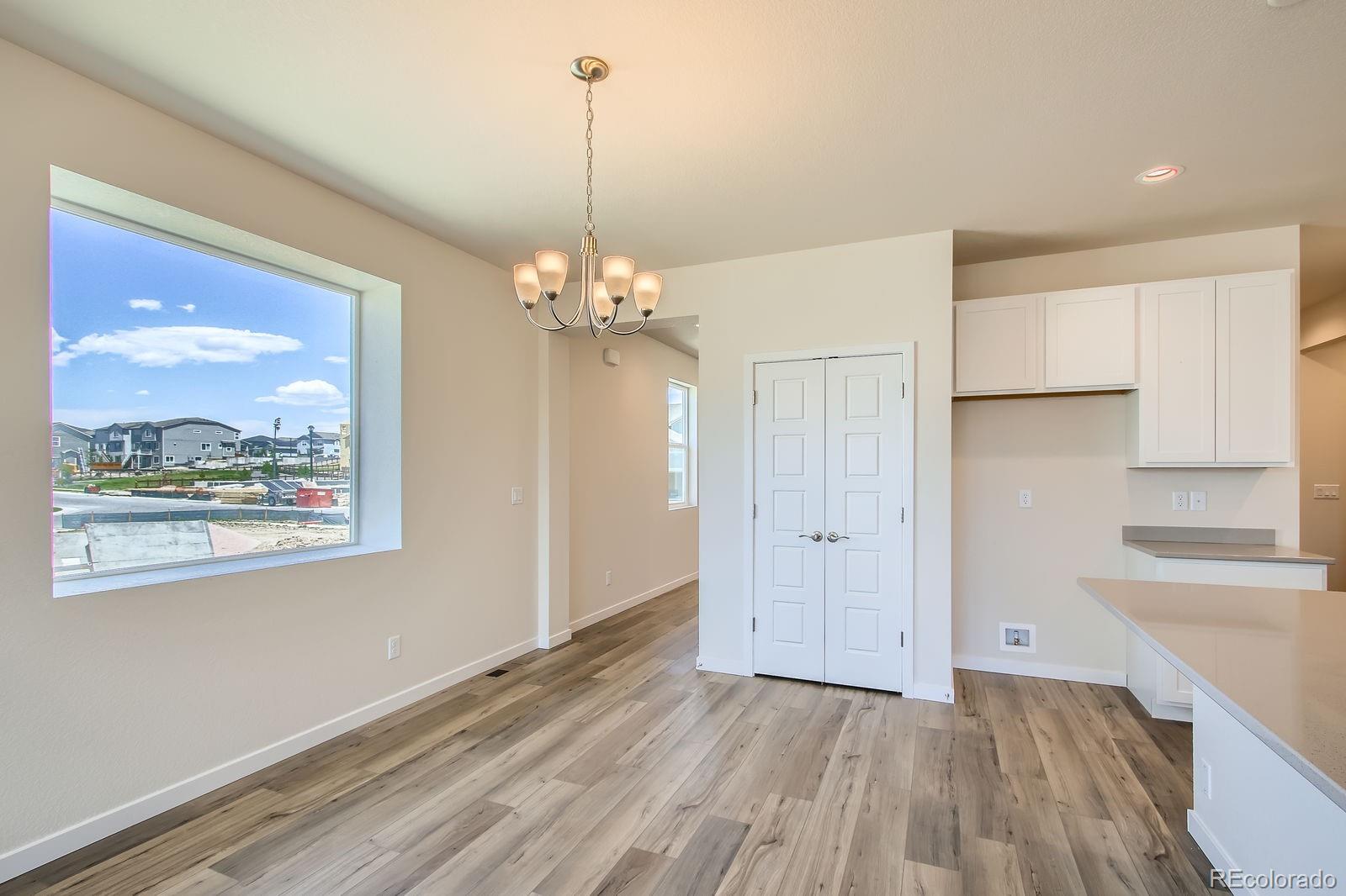 9085 Rifle Street Commerce City, CO 80022 - Photo 14 of 31 a view of a livingroom with a dishwasher cabinets and wooden floor