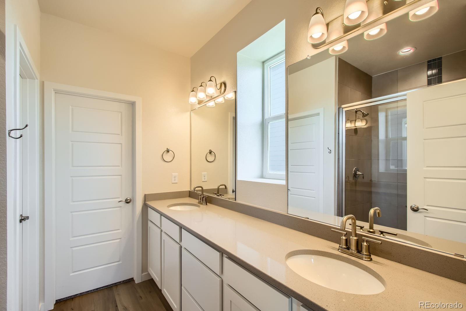 9085 Rifle Street Commerce City, CO 80022 - Photo 17 of 31 a bathroom with a sink double vanity and a mirror