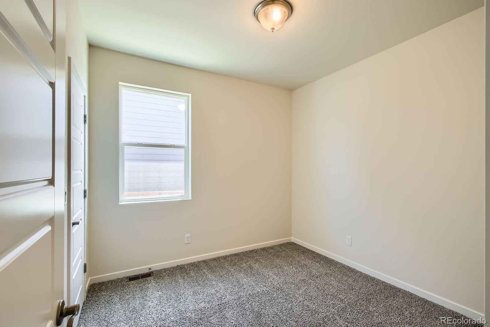 9085 Rifle Street Commerce City, CO 80022 - Photo 19 of 31 an empty room with windows