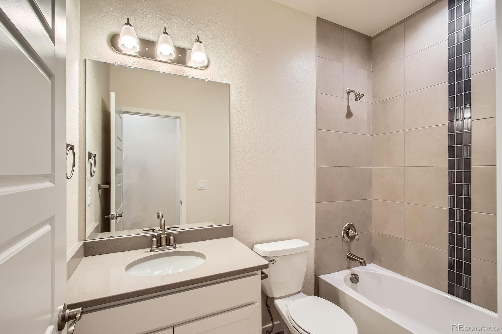 9085 Rifle Street Commerce City, CO 80022 - Photo 20 of 31 a bathroom with a sink vanity granite toilet tub and shower