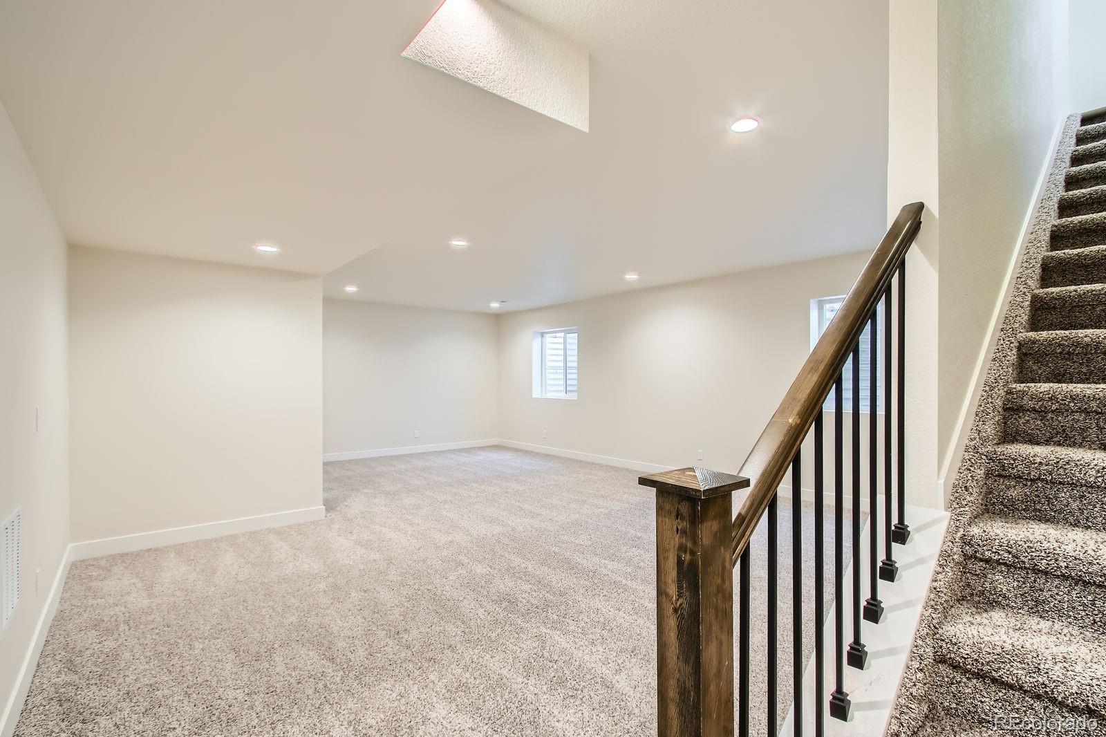 9085 Rifle Street Commerce City, CO 80022 - Photo 21 of 31 wooden floor in an empty room with stairs