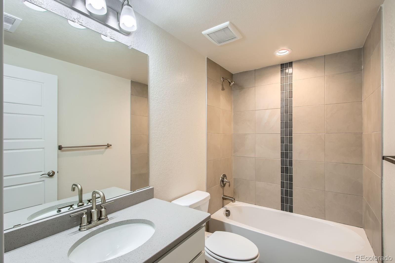 9085 Rifle Street Commerce City, CO 80022 - Photo 23 of 31 a bathroom with a sink a toilet a mirror and shower