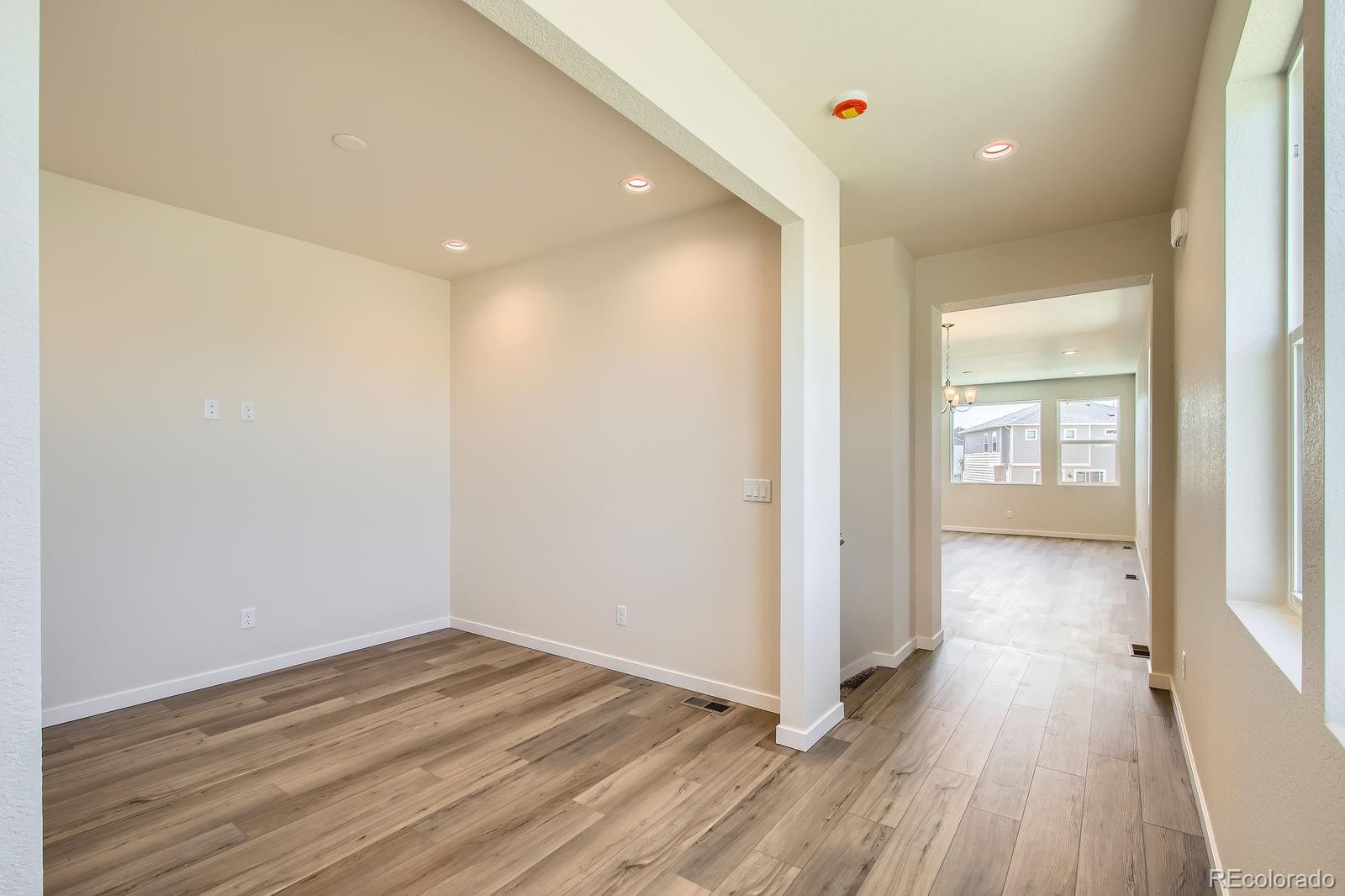 9085 Rifle Street Commerce City, CO 80022 - Photo 27 of 31 a view of a hallway with wooden floor and closet area