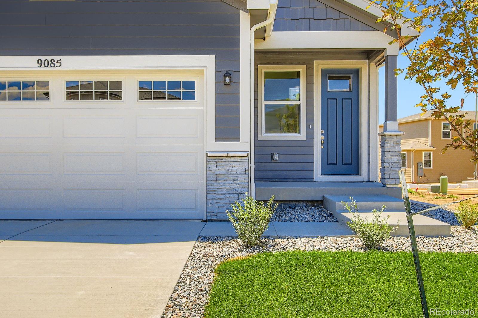 9085 Rifle Street Commerce City, CO 80022 - Photo 4 of 31 a front view of a house with a yard