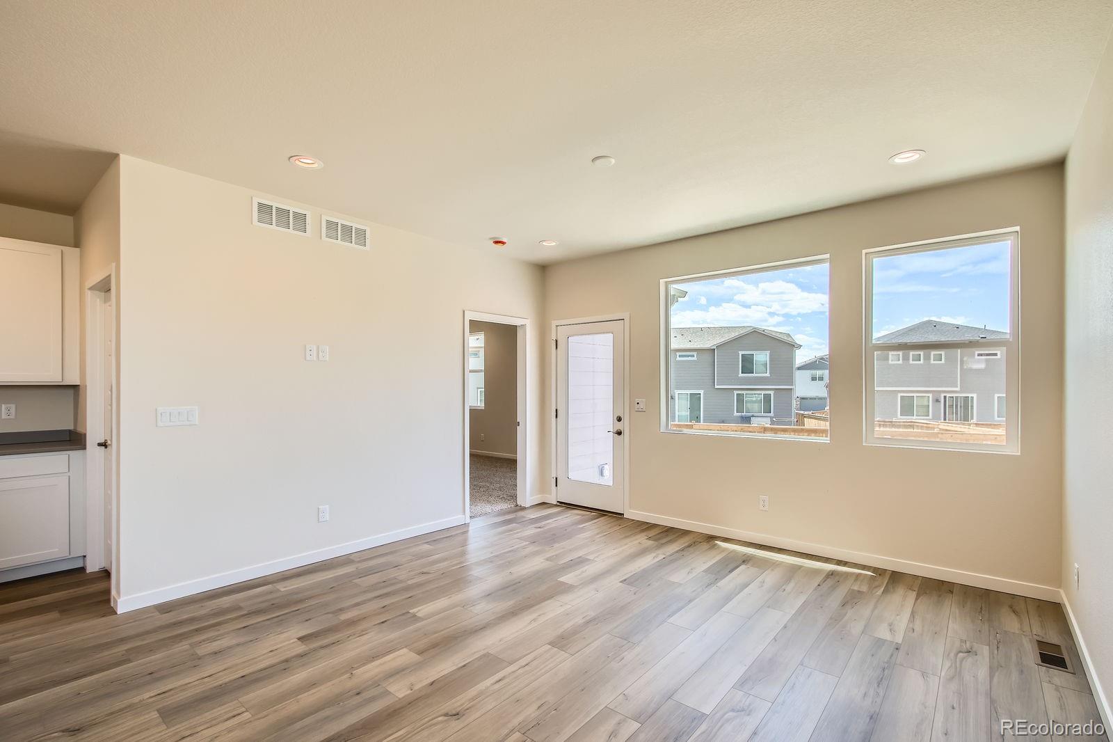 9085 Rifle Street Commerce City, CO 80022 - Photo 7 of 31 an empty room with wooden floor and windows