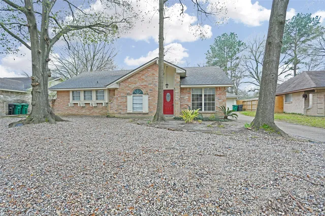 a view of a house with a yard and large tree
