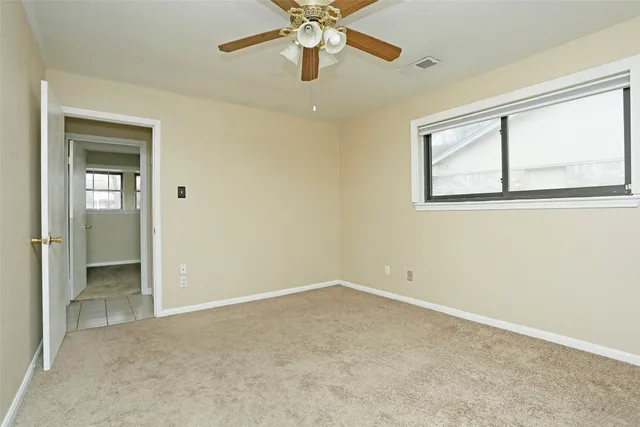 an empty room with a fan and a fan