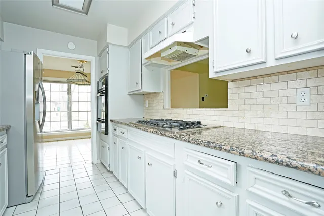 a kitchen with granite countertop a sink stove and cabinets