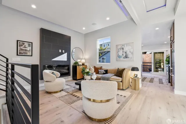 a living room with furniture a table and kitchen view