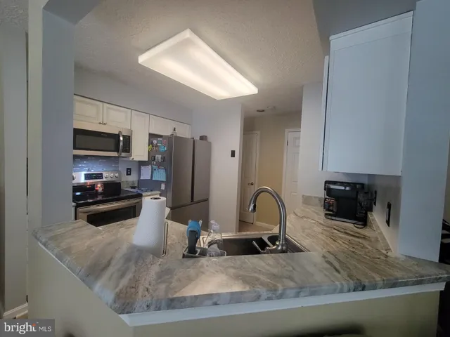 a kitchen with sink a stove and refrigerator