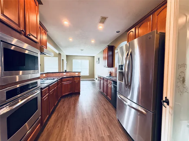 a kitchen with stainless steel appliances a refrigerator and a stove top oven