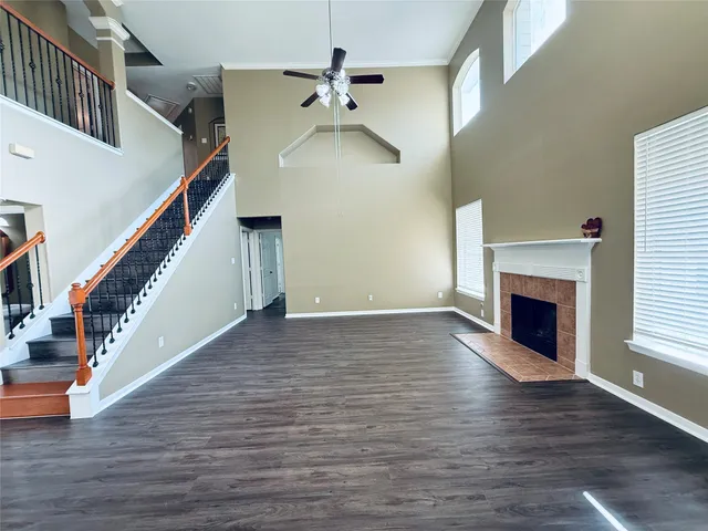 a view of a livingroom with wooden floor fireplace and stairs