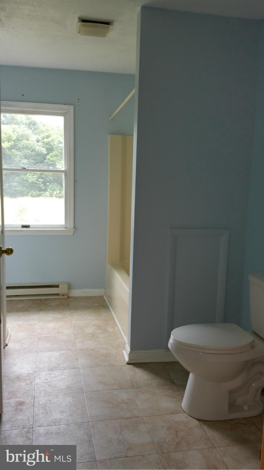 13727 Barnhart Road Clear Spring, MD 21722 - Photo 6 of 20 a white toilet sitting in a bathroom next to a window