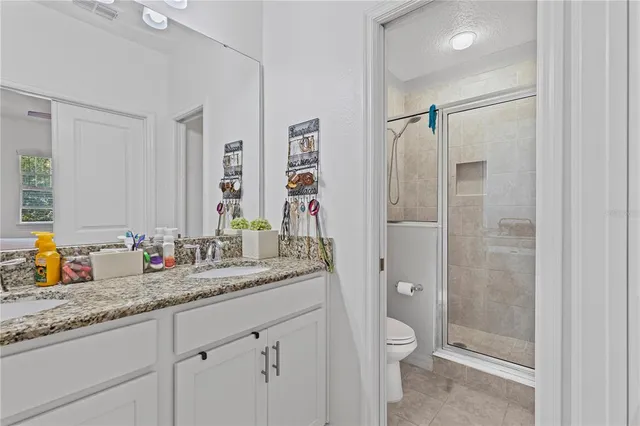 a bathroom with a granite countertop sink toilet and shower
