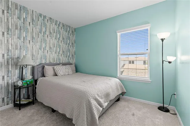 a bedroom with a bed table and a window