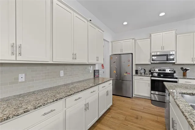 a kitchen with stainless steel appliances granite countertop a refrigerator sink and stove
