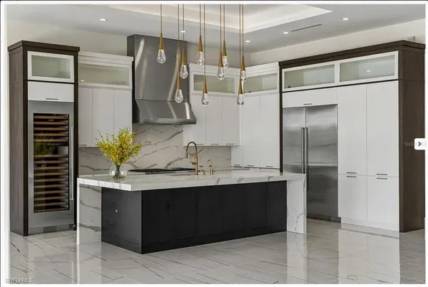 a kitchen with stainless steel appliances granite countertop a sink and a refrigerator