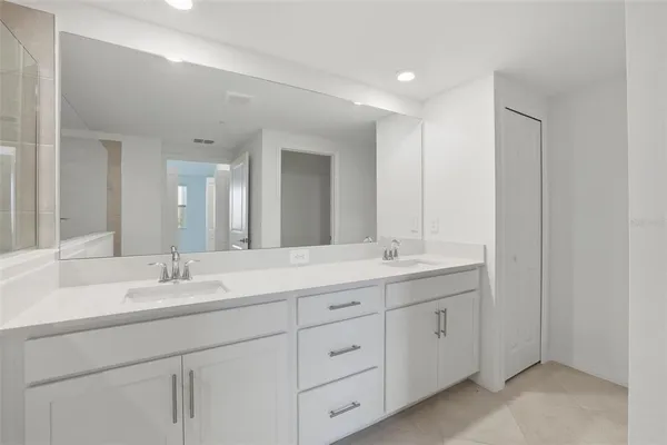 a bathroom with double sink and a mirror