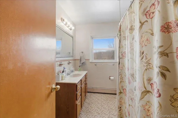 a bathroom with a sink and mirror with toilet
