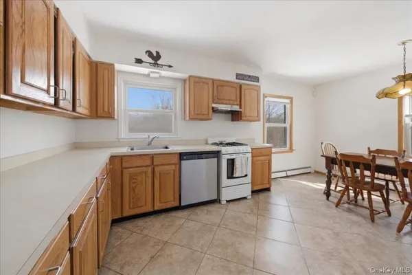 a kitchen with granite countertop a sink cabinets and stainless steel appliances