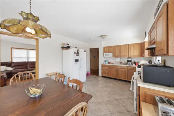 a kitchen with stainless steel appliances granite countertop a sink dishwasher stove top oven a dining table and chairs with wooden floor