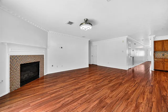 a view of empty room with wooden floor and fireplace