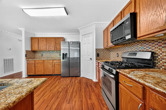 a kitchen with stainless steel appliances granite countertop a stove a sink and a microwave