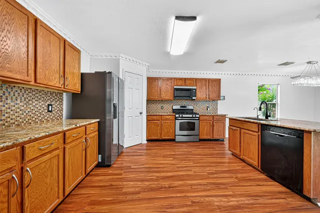 a kitchen with stainless steel appliances a refrigerator and a stove top oven
