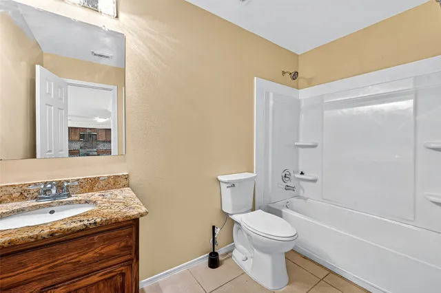 a bathroom with a granite countertop toilet a sink and a bathtub