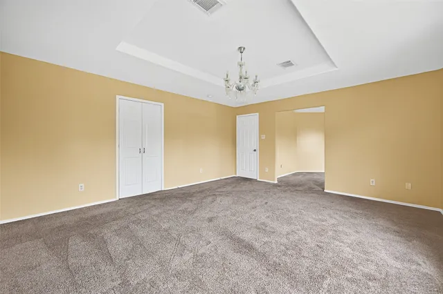 a view of a big room with windows and chandelier