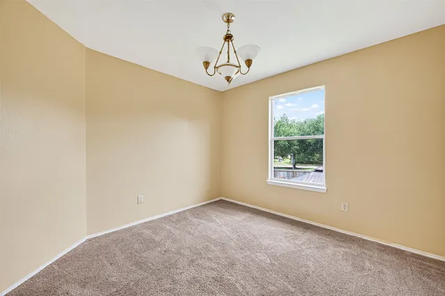 an empty room with windows and chandelier