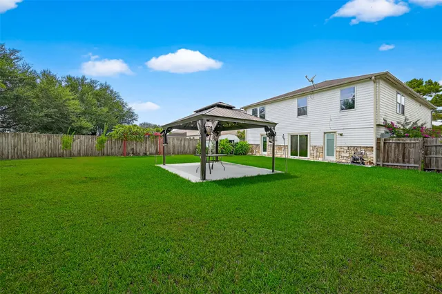 a view of a house with backyard and a tree